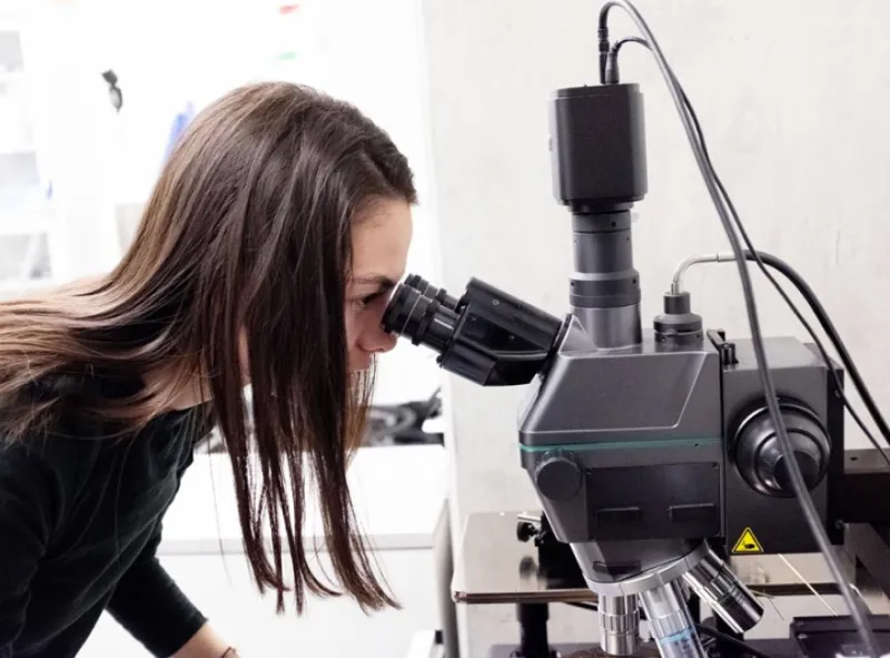 Women peering through microscope